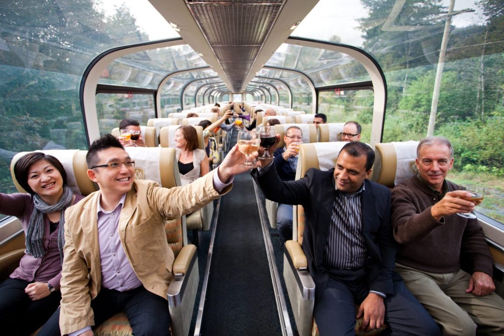 People toasting on a glass domed train