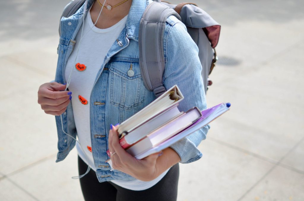 girl holding books heading back to school