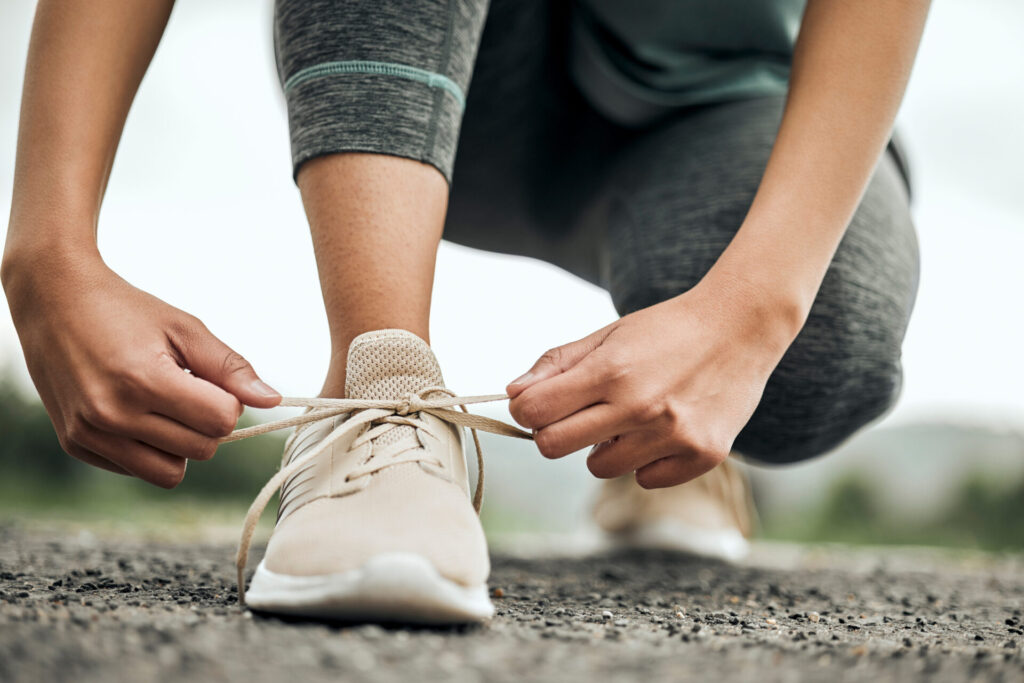 Shot of an unrecognizable person tying their shoelaces before a run