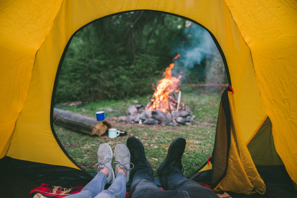 couple resting in tent with view on fire