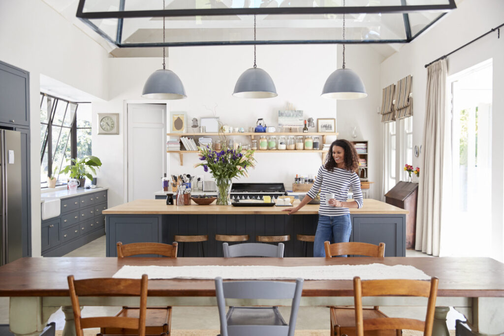 woman leaning on kitchen island in open plan home