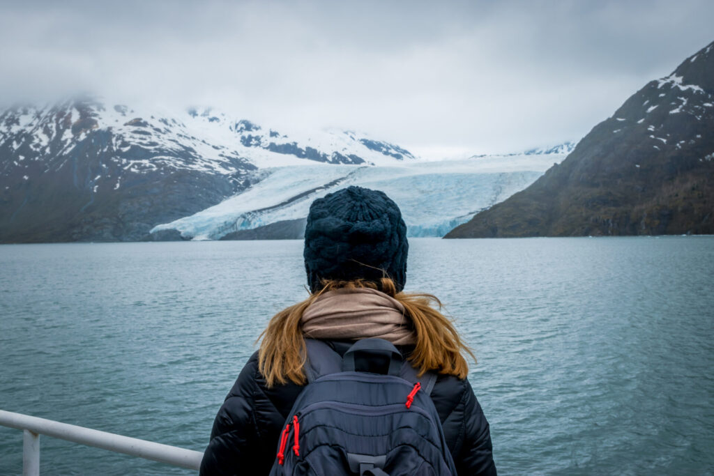 Woman looking at mountain range and glacier.