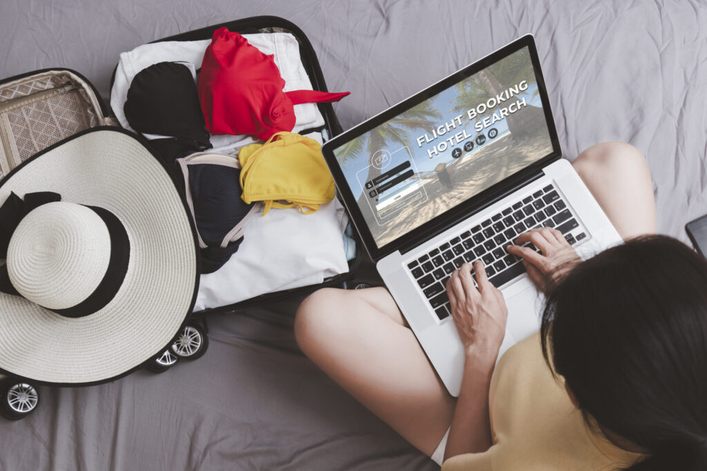 woman plan for trip by laptop booking hotel on the bed at home. Women with travel bag use notebook computer internet booking hotel. Holiday summer vacation concept