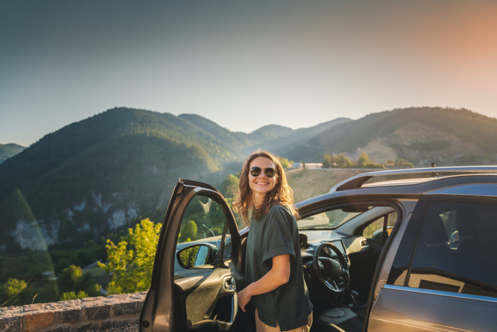 woman traveling by car in the mountains, summer vacation