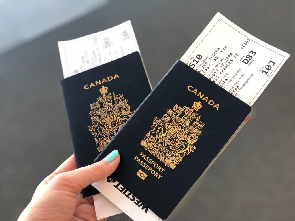person holding two Canadian passports