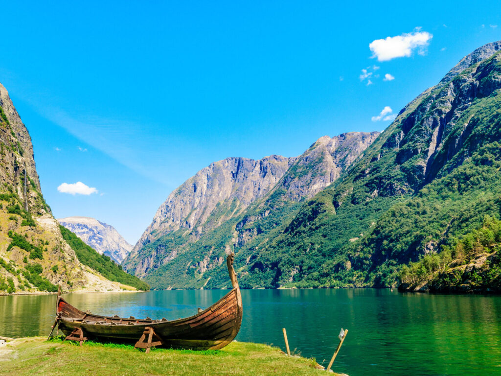Mountains and fjord Sognefjord in Norway, Scandinavia with an Old viking boat on seashore.