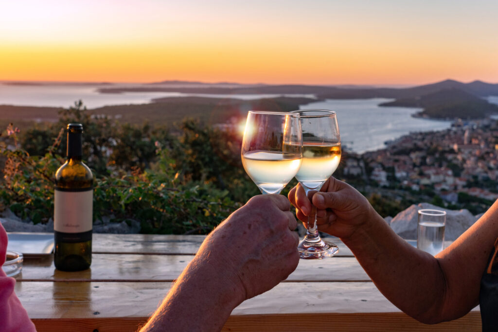 making a toast with wine over a scenic view of the croatian losinj islands in the kvarner gulf at sunset