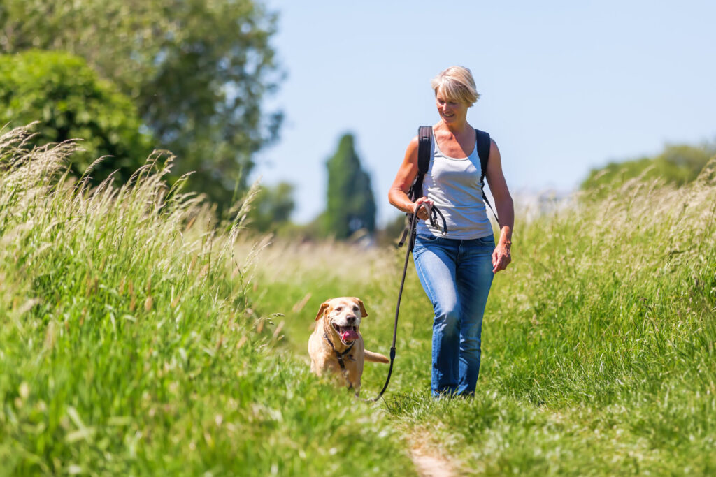woman hiking with a dog at the leash