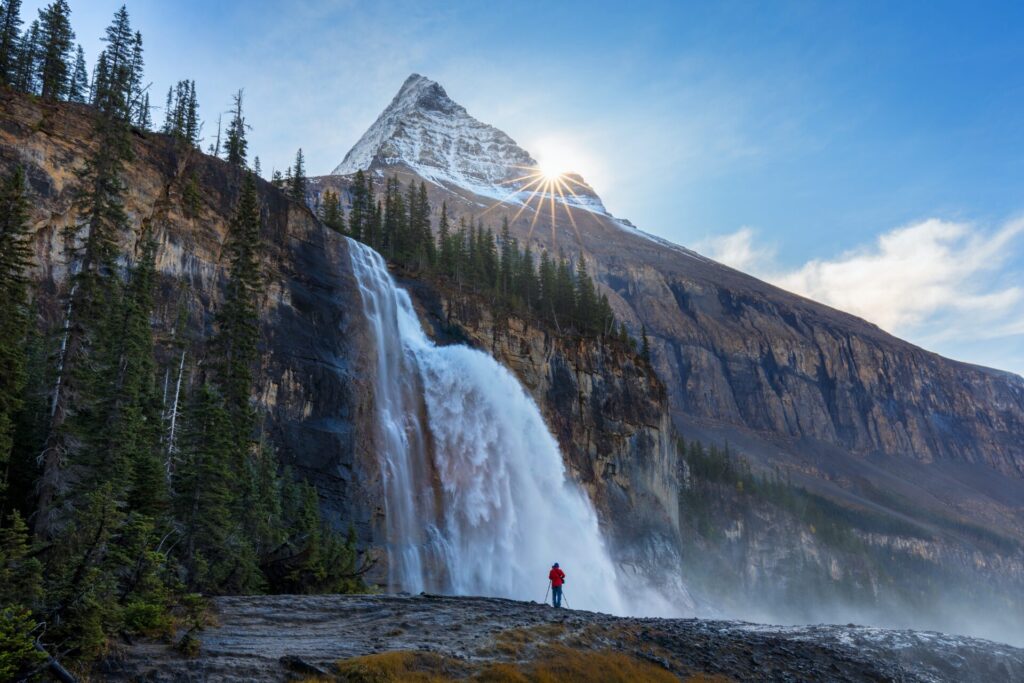A man stand before Emperor Falls and Mount Robson, Emperor Ridge along Berg Lake Hiking Trail in Canadian Rocky Mountains. Beautiful landscape background concept