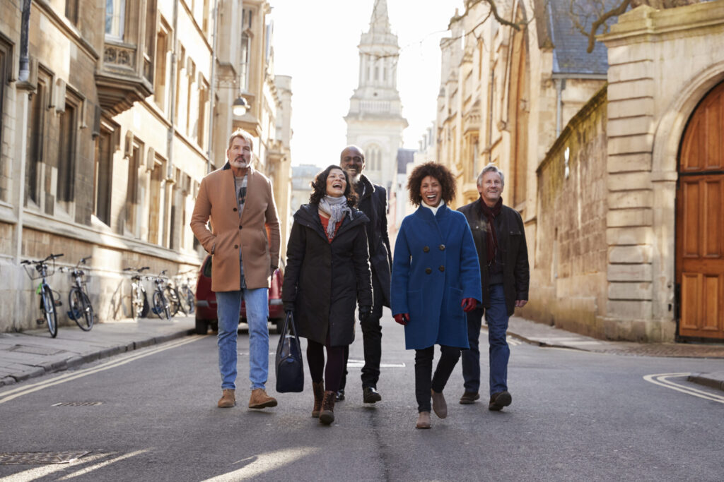 Group Of Mature Friends Walking Through City In Fall Together