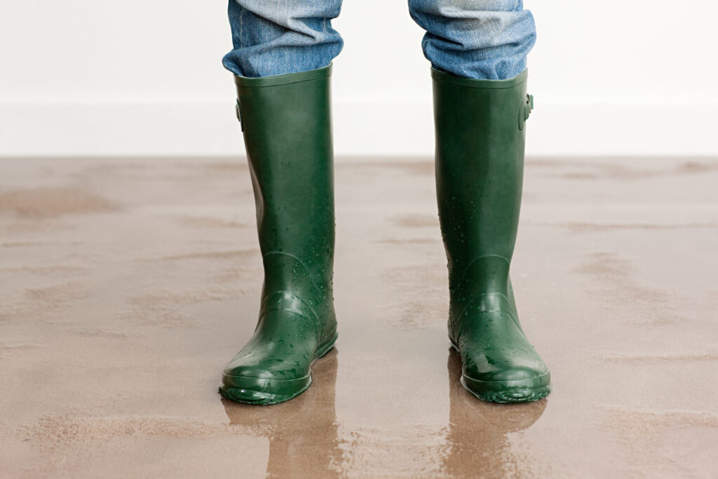 Man in wellington boots on flooded floor