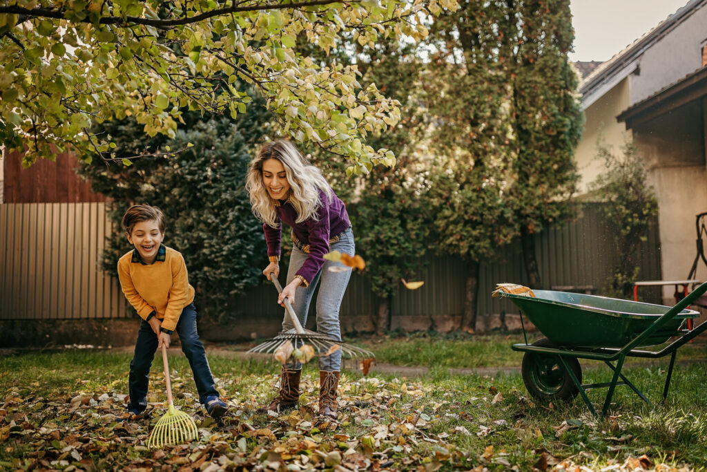 Mother and son playing in backyard with gardening equipment