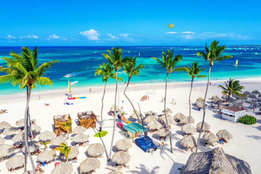 Beach vacation. Aerial drone view of tropical white sandy Bavaro beach in Punta Cana, Dominican Republic. Amazing landscape with palms, umbrellas and turquoise water of atlantic ocean