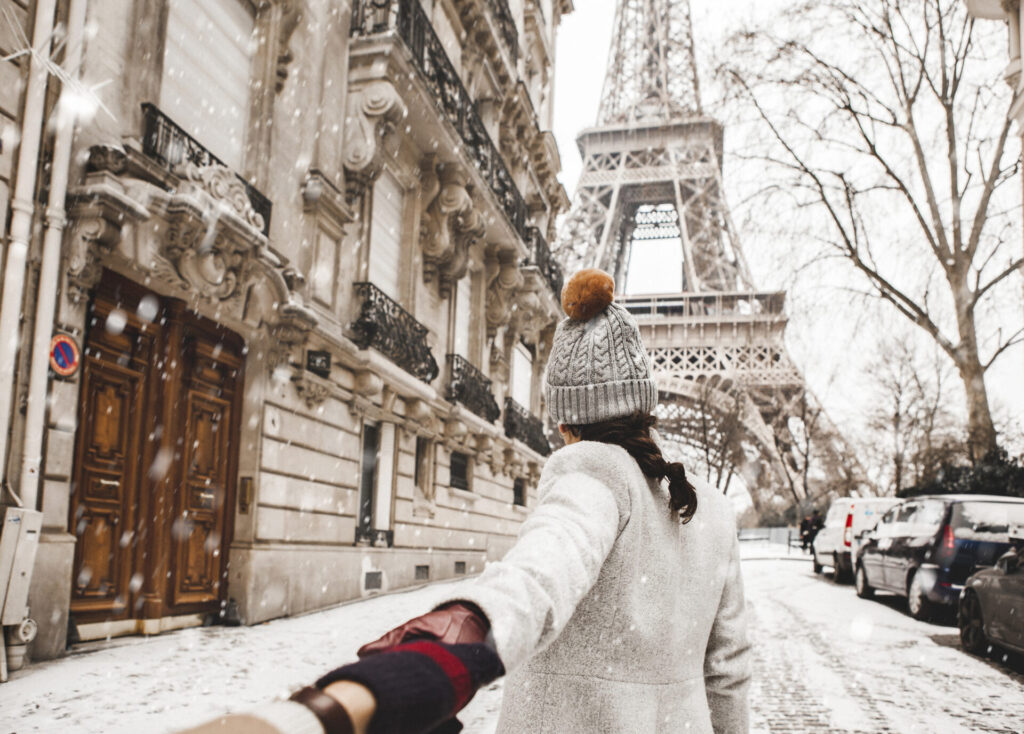 Woman walking to the Eiffel tower with snow