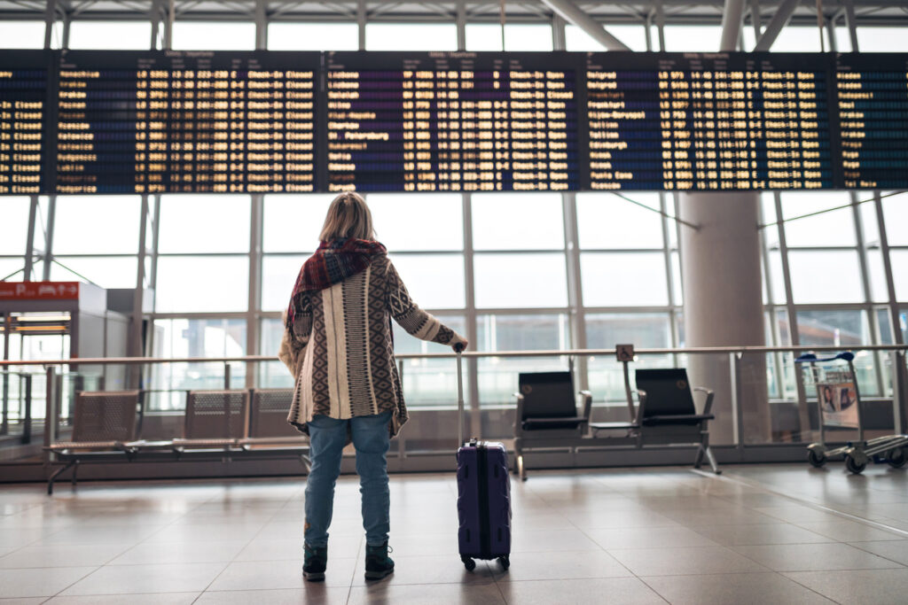 Woman reading departure board on airport