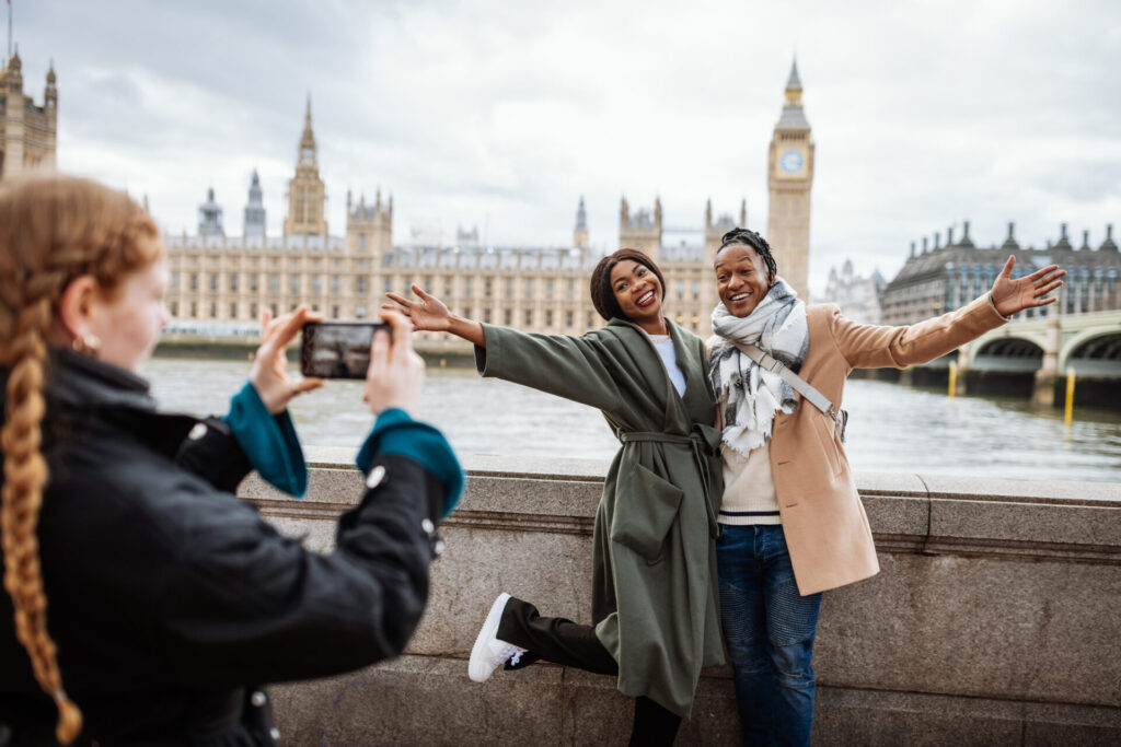 couple are tourist in London, in wintertime. Redhead woman taking pictures with smart phone