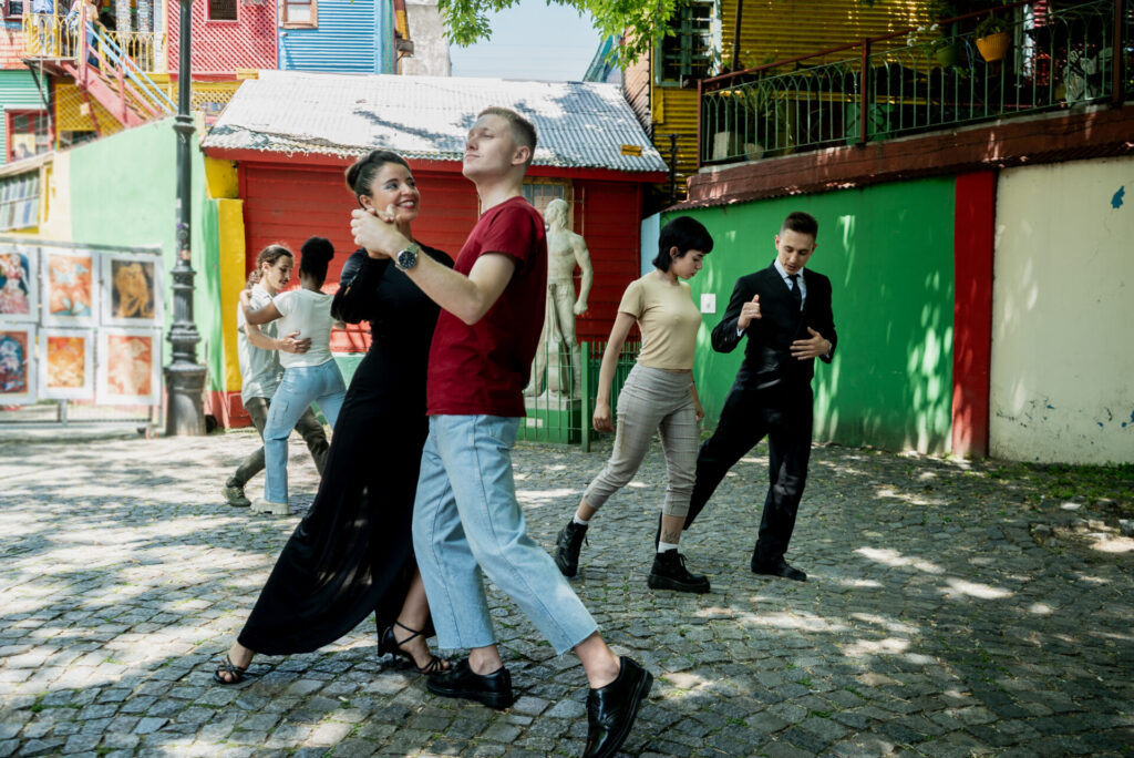 Street artist woman teaching tango to tourist on Caminito, Buenos Aires, Argentina